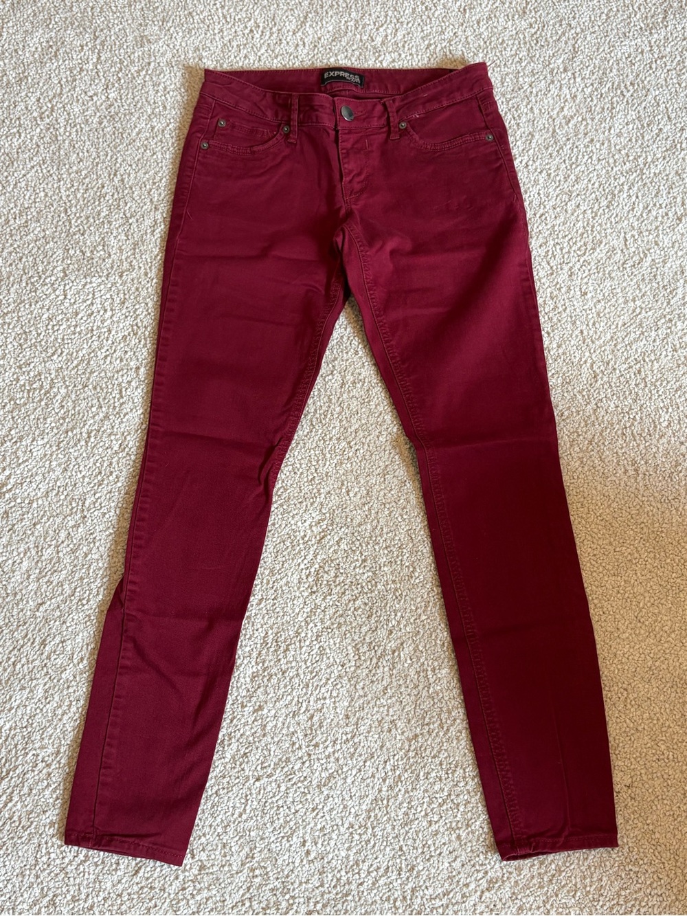 Express burgundy skinny jeans
